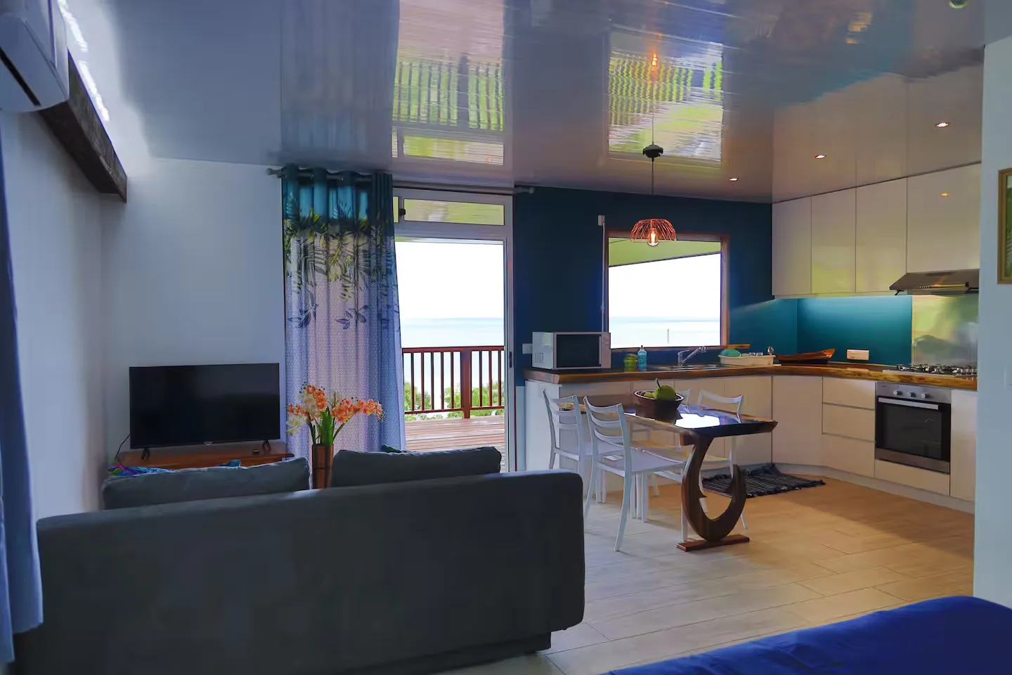 Le Studio — salon, cuisine et accès au deck
